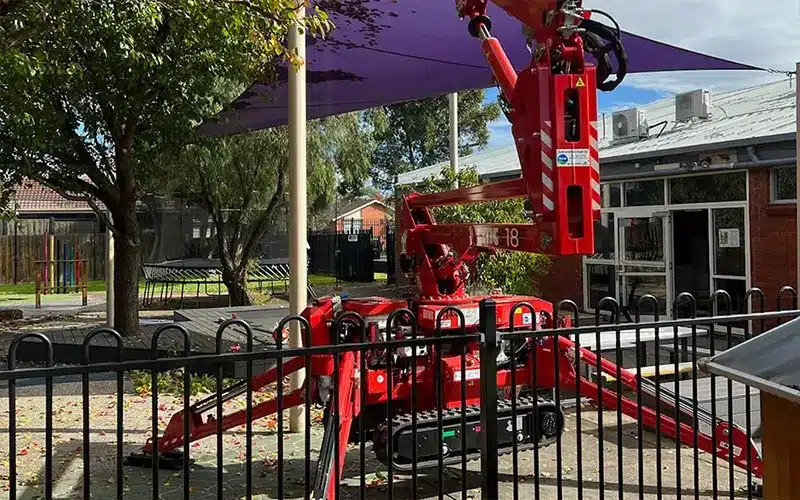 Arborist using a cherry picker for safe tree removal at a Melbourne residential property.